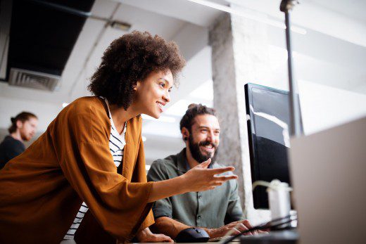 Projeto de software - duas pessoas olhando para o monitor de um computador